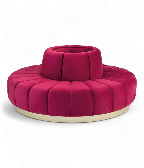Banquette circulaire design en velours rose fuchsia avec socle en laiton doré pour lobby d'hôtel.