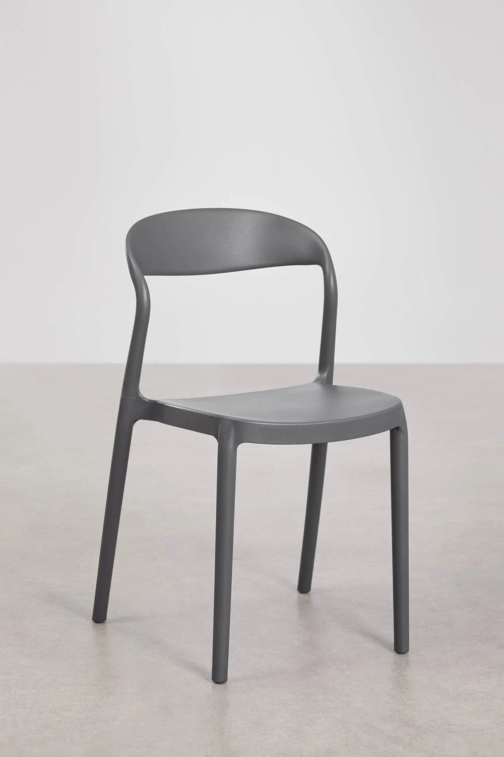 Lot de chaises empilables Brenza autour d'une table à manger contemporaine.