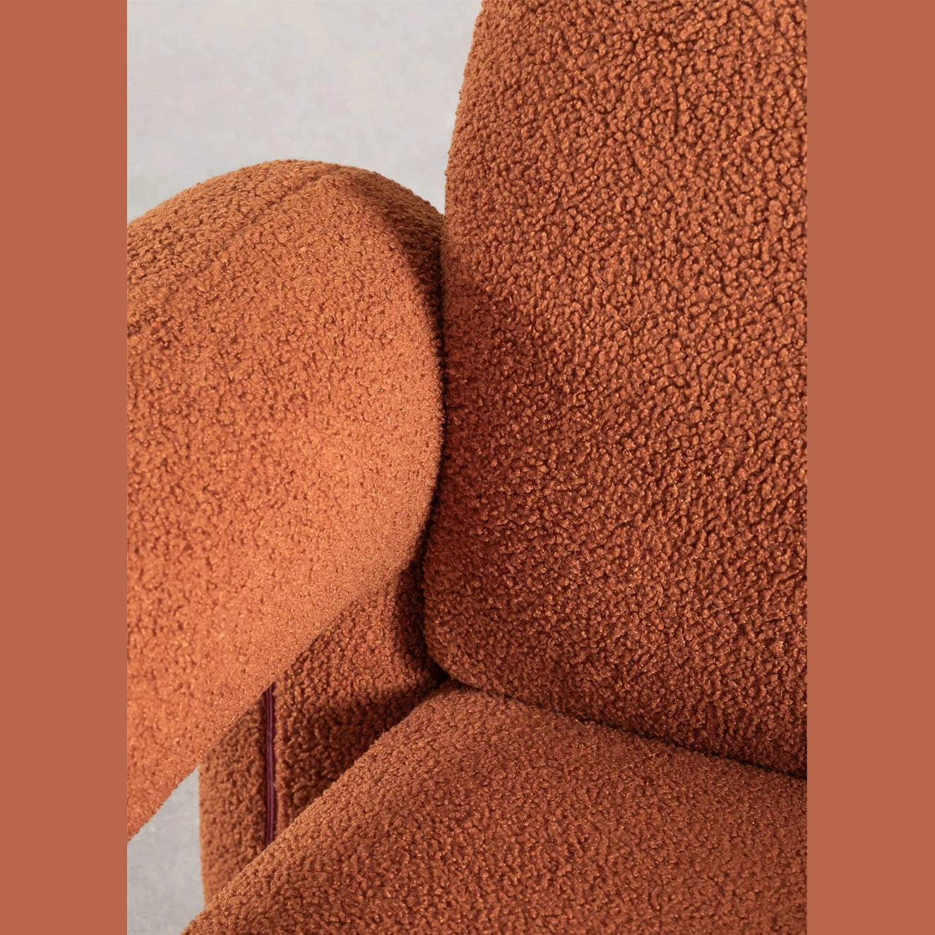 Fauteuil Alma en tissu effet bouclette offrant une assise confortable et un style moderne.