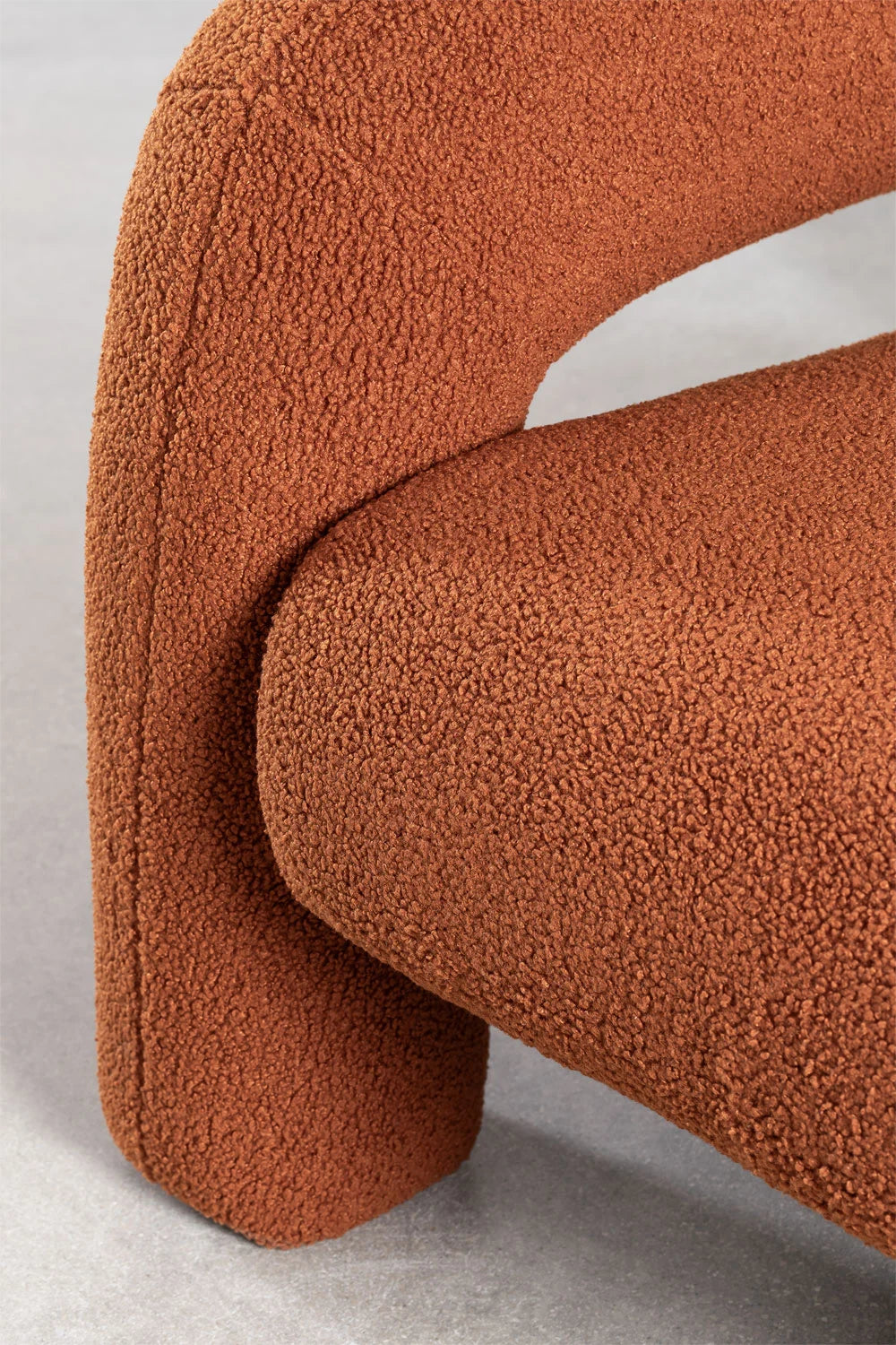 Fauteuil Alma au design contemporain avec revêtement bouclette et pieds intégrés.