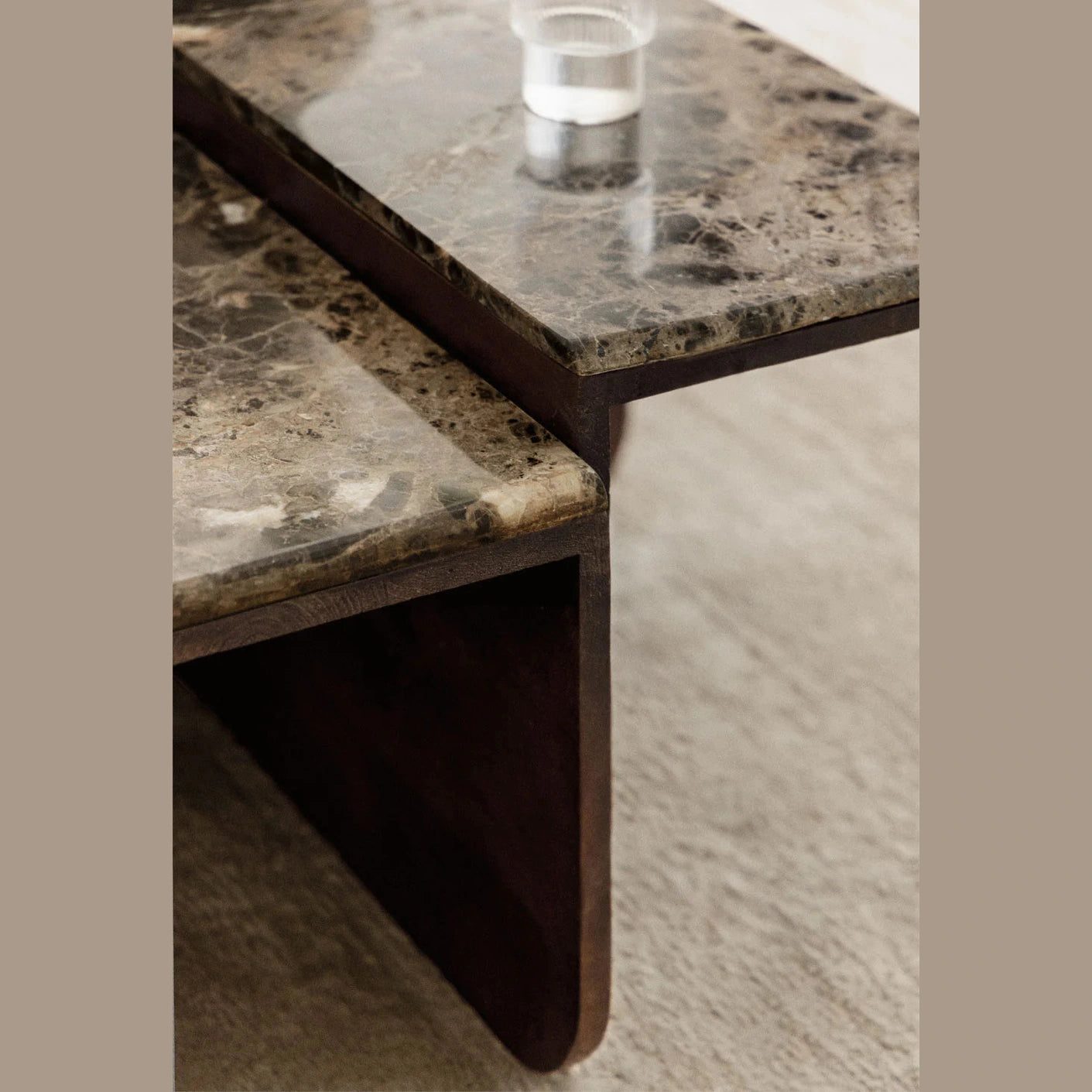 Ambiance de salon élégante avec la table basse Clotsh en pierre et bois devant un canapé design.