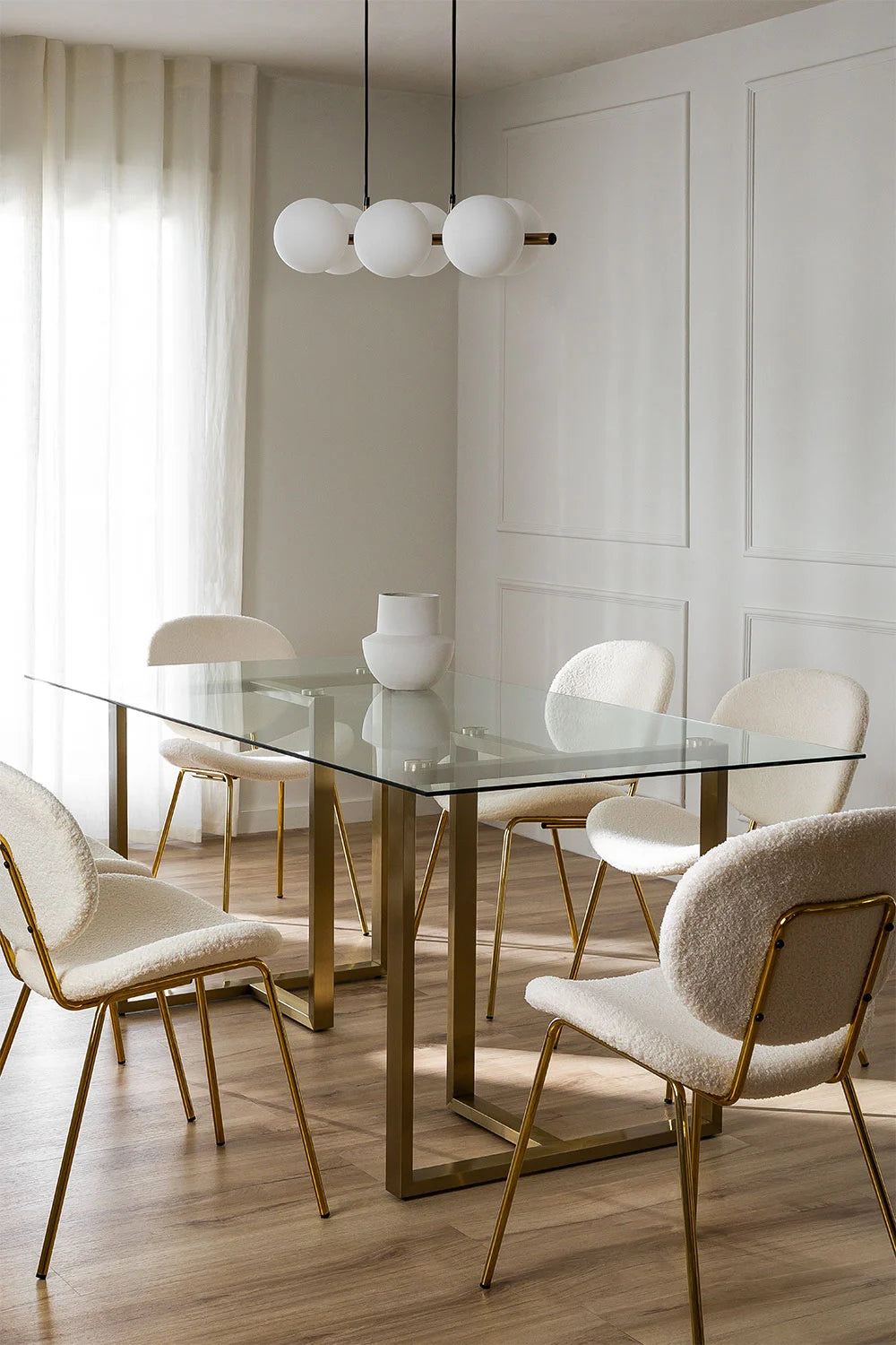 Salle à manger spacieuse avec table Leslie chaises design et luminaire suspendu.