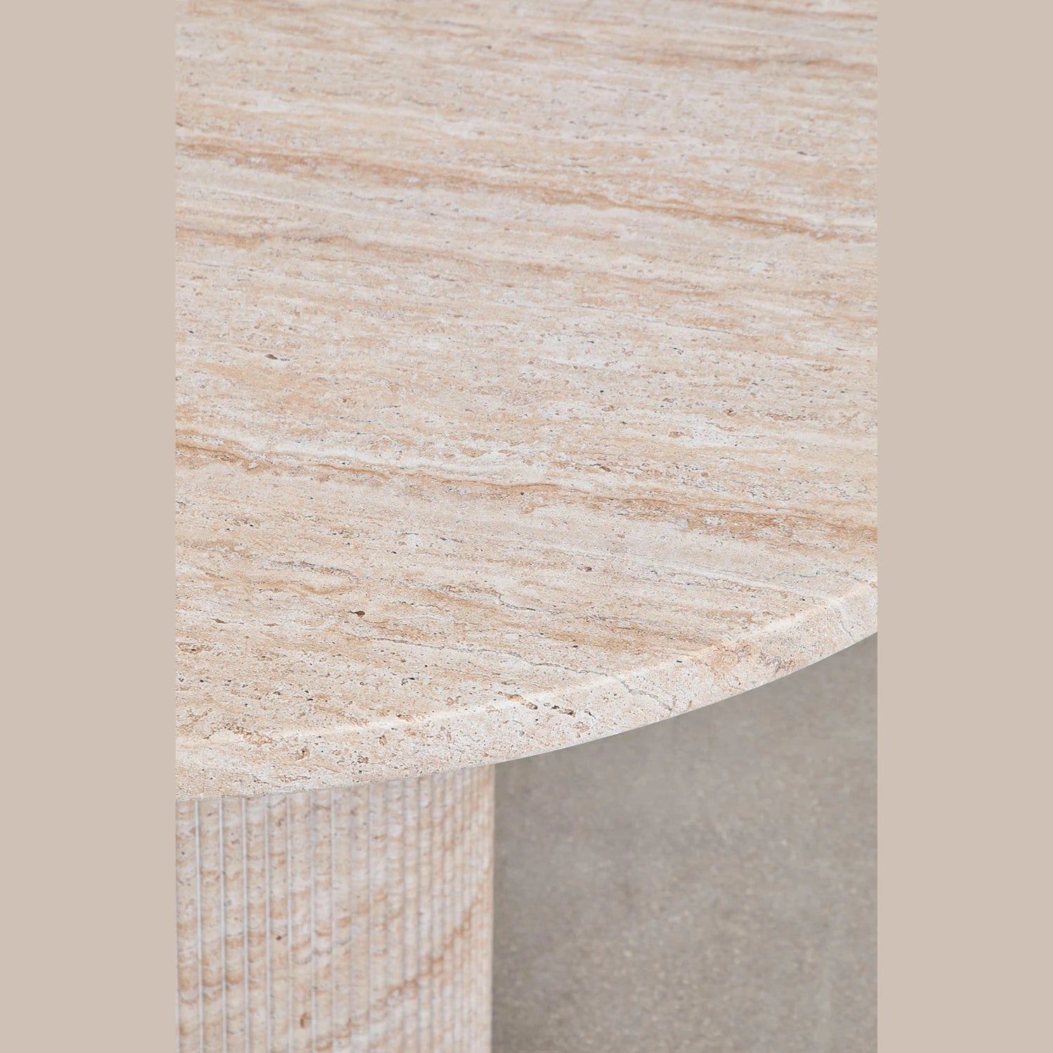 Zoom sur la finition effet pierre travertin du plateau de la table Velia.